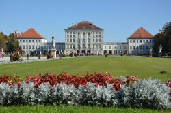 Schloss Nymphenburg in München mit Blumenbeet und Statuen davor