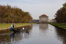 Venezianische Gondel auf dem Nymphenburger Schlosskanal in München mit Schloss Nymphenburg im Herbst